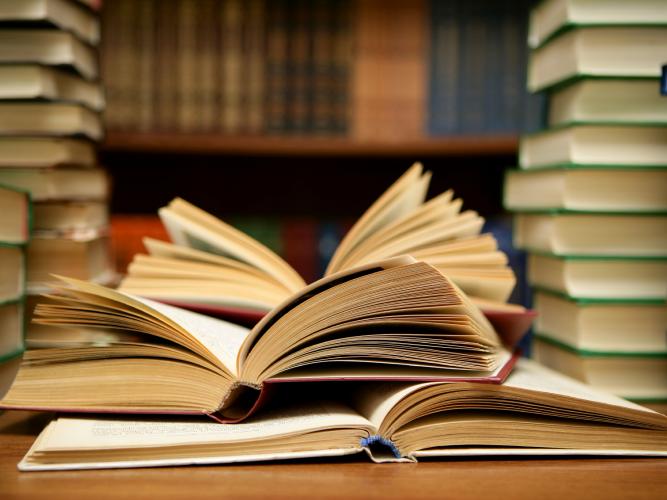 open books next to piles of books