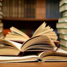 open books next to piles of books